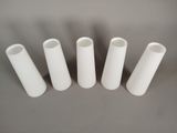four white plastic tubes lined up in a row on a gray surface