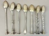 six silver spoons are lined up in a row on a table