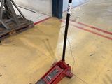 a red jack sitting on the floor next to a pile of junk