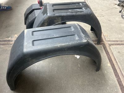 deux tabourets en plastique noir posés sur le trottoir