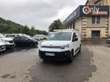 La camionnette blanche est garée devant un immeuble dans la rue.