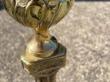 a gold vase sitting on a pedestal on the ground