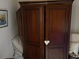 une grande armoire en bois dans le coin d'une pièce