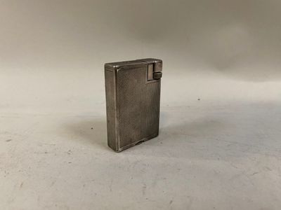 un petit briquet argenté posé sur une surface blanche