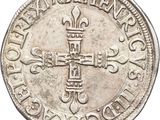 a close up of a silver coin with a cross on it