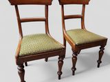 deux chaises en bois avec des coussins rembourrés verts posés dessus