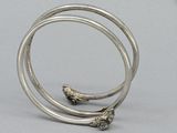 two silver bang bracelets sitting on top of each other on top of a table