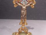 a gold cross with a blue and red design on it