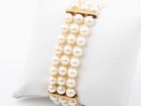 a close up of a bracelet with pearls on a pillow