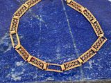 un gros plan d'un bracelet en or orné d'une pierre bleue