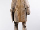 an old wooden statue of a man with a hat and a book