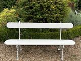 un banc blanc posé au milieu d'une aire de gravier