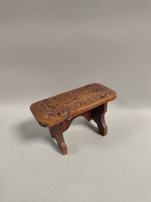un petit banc en bois orné d'un motif sculpté