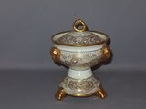 a small white and gold bowl with a gold ring on it