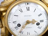 a gold clock with roman numerals on the face