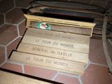 a suitcase sitting on the floor with a bunch of books on top of it