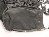 a black purse with fringes on it sitting on a white surface