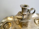 a silver plate with a silver vase on it