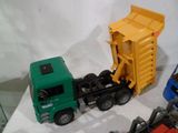 trois camions jouets et un camion-benne sur une table