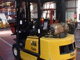 a yellow fork truck parked inside of a warehouse