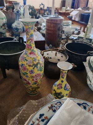 de nombreux vases et assiettes sur la table dans cette pièce