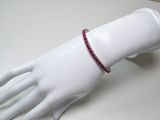 a white mannequin hand with a red bracelet on it