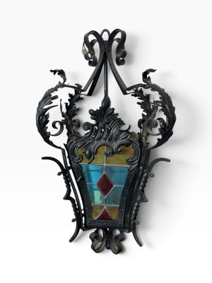 wrought iron wall sconce with a stained glass panel