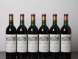 six bouteilles de vin alignées sur une table en bois