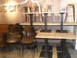 tables and chairs in a room with a brick wall behind them