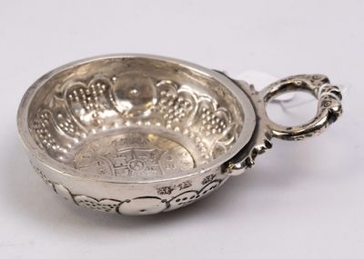an antique silver bowl with a handle and handles on a white surface