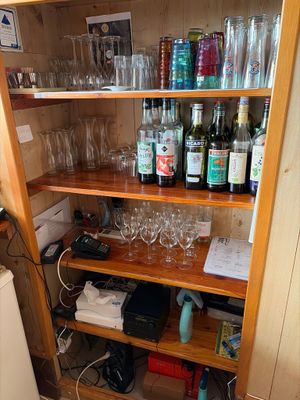a wooden shelf with wine glasses and other items on it