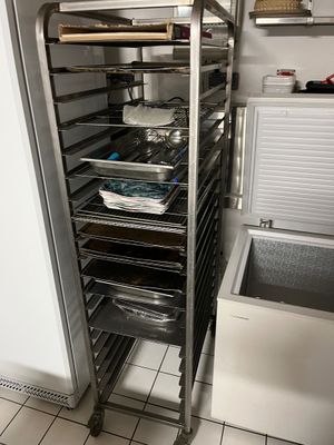 a metal rack with trays of food inside of it