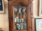 une armoire en bois avec une porte vitrée, dans un coin de la pièce
