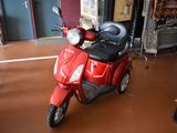 a red scooter that is parked in a room
