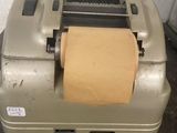 an old typewriter with a roll of paper on top of it
