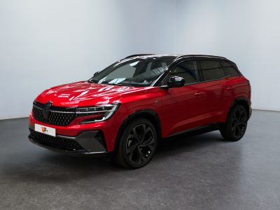 un SUV rouge garé dans une pièce blanche au sol noir