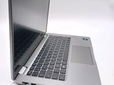 a silver laptop with a black keyboard on a white surface