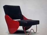 a red and black chair with a black seat on it