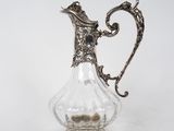 un pichet ancien en verre plaqué argent sur fond blanc