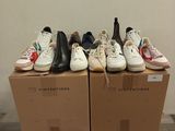 several pairs of shoes are stacked on top of boxes in a room