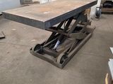 une table qui se trouve dans une pièce où il y a beaucoup d'outils