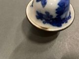 a small blue and white cup on a saucer on a table
