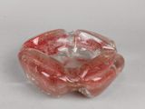 un bol en verre contenant une fleur rouge