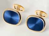 deux paires de boutons de manchette dorés et bleus sur fond blanc