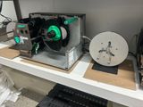 a machine that is sitting on a shelf next to a laptop
