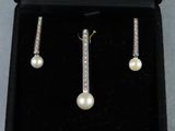 une paire de boucles d'oreilles en perles et diamants, présentée dans un écrin noir