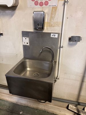 un évier en acier inoxydable dans le coin d'une salle de bains
