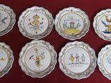 many plates with pictures of people on them on a red surface
