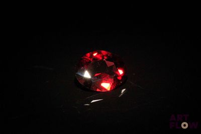 a close up of a red diamond in the dark