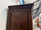 un grand meuble en bois surmonté d'une horloge
